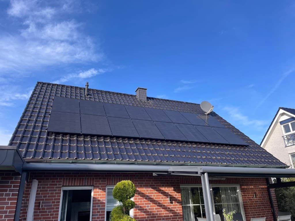 Ziegelhaus mit zehn vollschwarzen Photovoltaikmodulen auf dem Dach